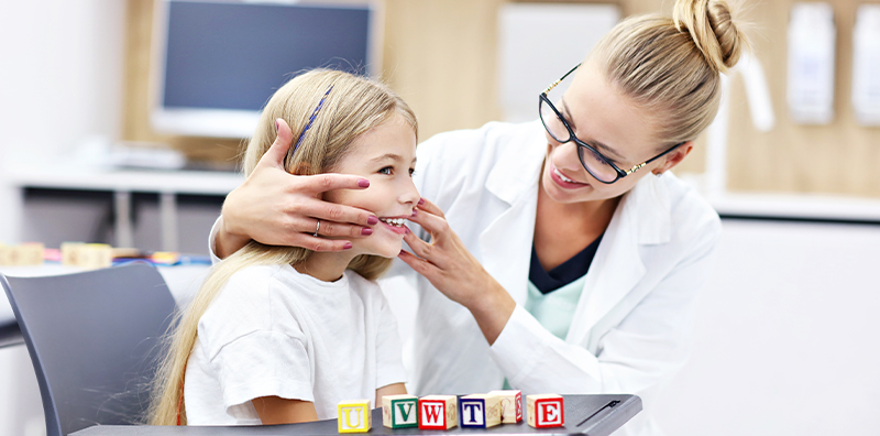 orthophoniste en consultation avec une petite fille